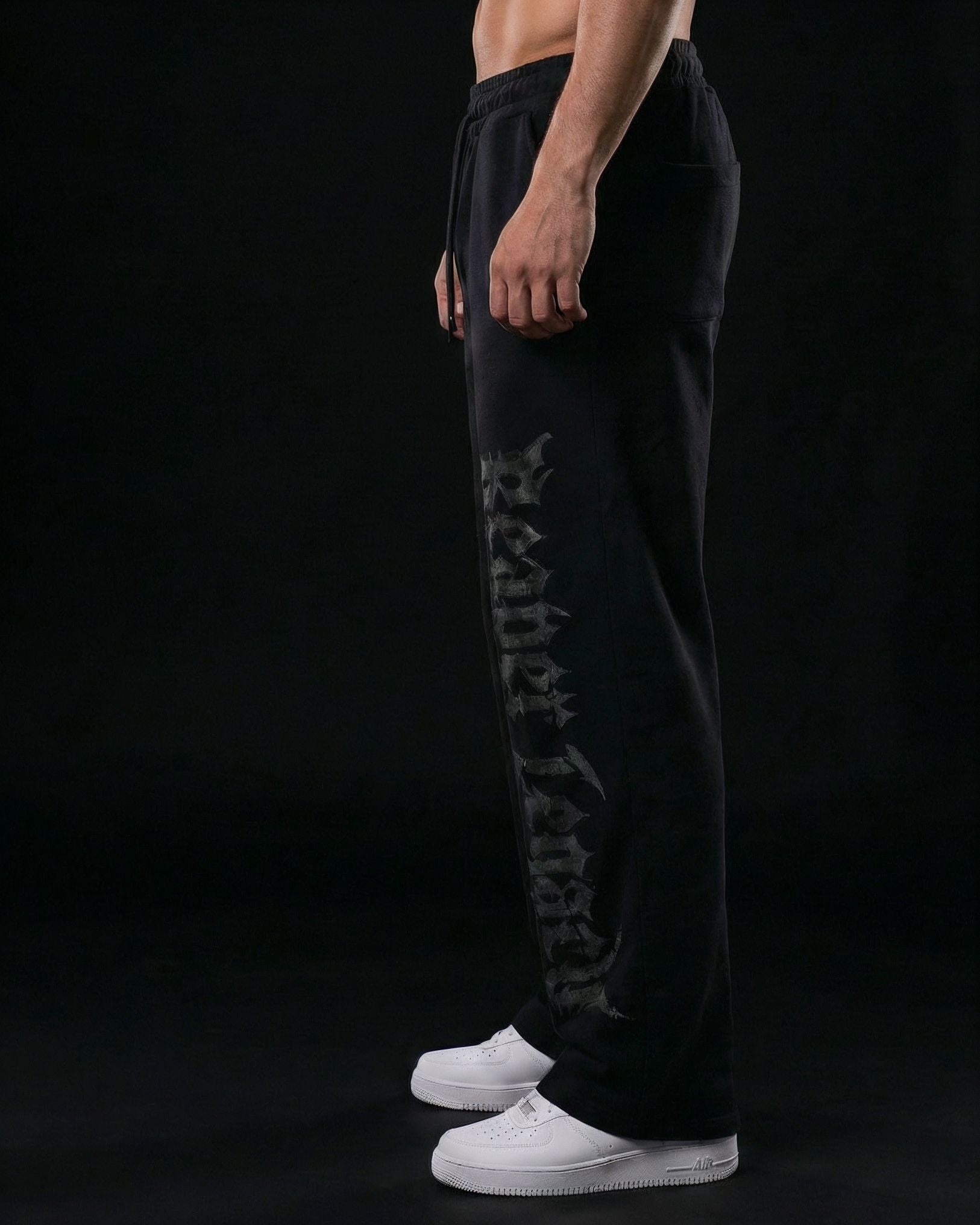 Pantalones baggy negros The Grave Walker de Reaper con tipografía gótica vertical, confeccionados en French Terry de alto gramaje para una caída pesada